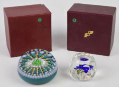 Two Perthshire glass paperweights, one faceted and decorated with a blue flower the other with