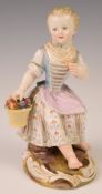 Meissen seated child figure eating an apple from a basket of fruit, with Dresden lace decoration