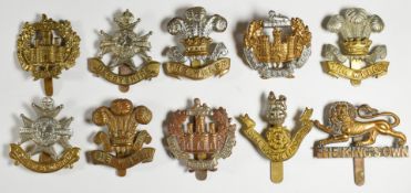 Ten British Army Infantry regiment cap badges including Essex Regiment, Derbyshire Regiment and