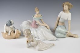 Four Nao figurines including a seated girl in a ballgown, puppies playing etc, tallest 22cm