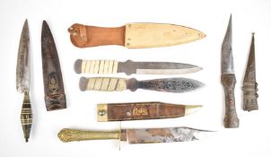 Three Oriental daggers, all with sheaths, longest blade 19cm together with two throwing knives,