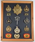 Mounted display of 14 Royal Marines badges including brass and anodised examples The badges have not