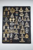 Mounted display of approximately 50 British Army metal and anodised badges including Royal