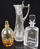 Three glass jugs and decanters comprising an Orrefors clear faceted decanter, an amber glass
