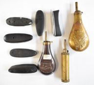Three various powder flasks including a cylindrical example and six shotgun butt plates.