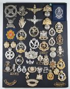 Mounted display of approximately 50 British Army cap badges, mostly metal and anodised including