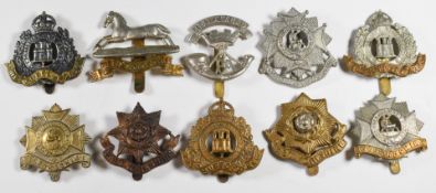 Ten British Army cap badges including Suffolk Regiment, Bedfordshire Regiment and East Yorkshire