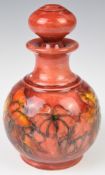 Moorcroft scent bottle and stopper decorated in the flabé floral orchid pattern, with signature