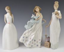 Three Lladro figurines including girl with parasol and a girl with a bird on her shawl, tallest
