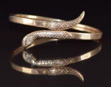 A 9ct gold bangle in the form of a snake set with diamonds and ruby eyes, 11.1g, 6 x 5cm