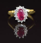 An 18ct gold ring set with an oval cut ruby of approximately 0.7ct surrounded by diamonds, 2.4g,