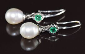 A pair of 18ct white gold earrings each set with a round cut emerald of approximately 0.28ct and a