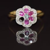 A c1920 18ct gold ring set with diamonds and rubies in a platinum flower cluster (one ruby missing),