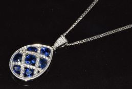 An 18k white gold pear shaped pendant set with oval cut sapphires, the largest sapphire