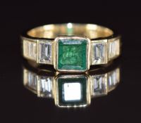 An 18k gold ring set with an emerald cut emerald of approximately 0.8ct and baguette cut diamonds of