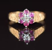 A 9ct gold ring set with a diamond surrounded by rubies, 1.8g, size M