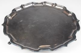 Elizabeth II hallmarked silver salver with shaped edge, raised on three feet, feature hallmarked