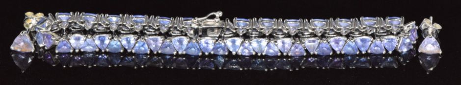 An 18k white gold bracelet set with 58 trilliant cut tanzanites each approximately 0.14ct, with a