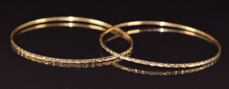 Two 18k gold bangles with cut out decoration, 10.9g, 6.3cm