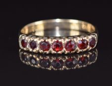 A 9ct gold ring set with seven round cut garnets, 2.3g, size Q