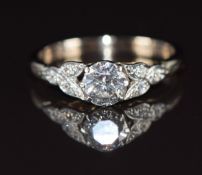 An 18ct gold ring set with a round cut diamond of approximately 0.6ct and diamond encrusted