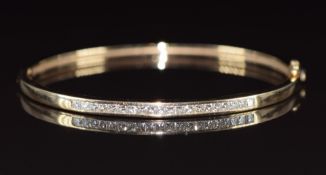 A 9ct white gold bangle set with princess cut diamonds, the total diamond weight approximately