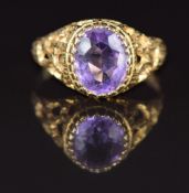 A 9ct gold ring set with an oval cut amethyst in a textured pierced setting, 2.6g, size P