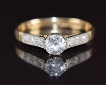 An 18ct gold ring set with a diamond of approximately 0.35ct, with diamond encrusted shoulders in