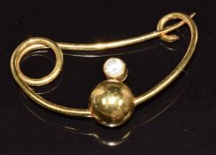 An 18k gold bespoke brooch in the form of an orb, set with a round cut diamond of approximately 0.