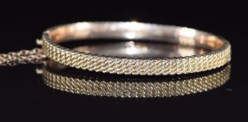A 9ct rose gold bangle with curb link decoration, Birmingham 1889, 9.1g, 4.9 x 5.8cm