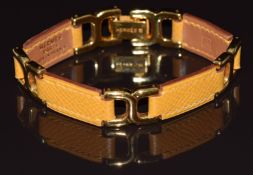 Hermès Beauvau articulated bracelet made up of mustard yellow leather and gold plated links, in