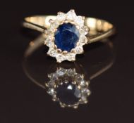 A 9ct gold ring set with an oval cut sapphire surrounded by diamonds, 1.7g, size K