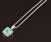 An 18ct white gold pendant set with an emerald cut emerald of approximately 0.58ct and diamonds