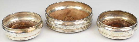 Three Elizabeth II hallmarked silver wine coasters, the largest London 1985, maker WEV, the other