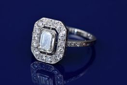 An 18ct white gold ring set with a 1ct emerald cut diamond surrounded by 14 round cut diamonds, each