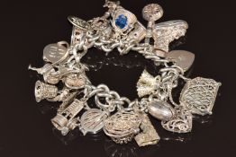 Silver charm bracelet with twenty-two silver charms including purse, clock, lobster pot opening to