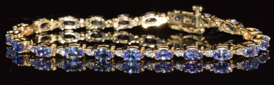 A 14ct gold bracelet set with 21 oval cut tanzanites and 21 round brilliant cut diamonds, the