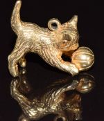 A 9ct gold charm in the form of a cat playing with a ball, 6.5g, 1.7cm