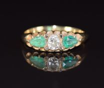 Victorian ring set with an old cut diamond of approximately 0.35ct and two pear cut emeralds, each