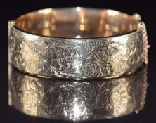 A 9ct gold bangle with engraved scrolling decoration, 28g, 6 x 5.5cm