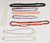 A collection of beaded necklaces including coral, amethyst, pearl etc