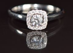 An 18k white gold ring set with a diamond of approximately 0.24ct surrounded by further diamonds