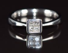 A 9ct white gold ring set with four princess cut diamonds, the total diamond weight approximately