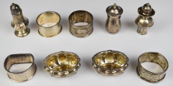 Hallmarked silver napkin rings and cruet items comprising four napkin rings, three peppers and a