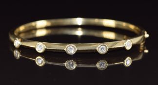 An 18k gold bangle set with five round cut diamonds, the total diamond weight approximately 0.5ct,