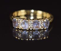An 18ct gold ring set with oval cut tanzanites and diamonds, 2.7g, size I