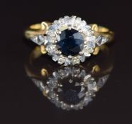 An 18ct gold ring set with a round cut sapphire of approximately 0.7ct surrounded by diamonds, 4.8g,