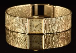 Omega 9ct gold ladies wristwatch with black hands, gold hour markers, silver dial and signed 17