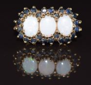 A 9ct gold ring set with three oval opals surrounded by sapphires, 4g, size N
