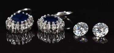 A pair of silver earrings set with a sapphire and cubic zirconia and two moissanites of